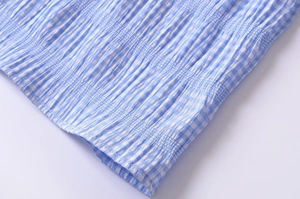 Close-up of light blue and white checkered fabric texture with high-quality stitching