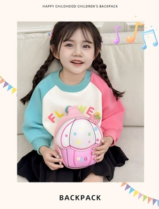 Detail showing a girl holding a cute cupcake shaped pink backpack with strawberry patterns