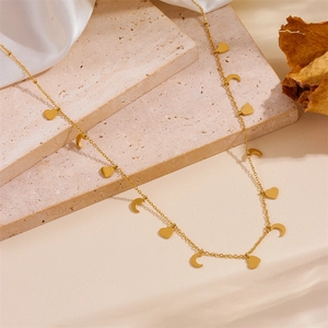 Detailed close-up of gold stainless steel necklace with small heart and moon charms
