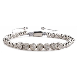 Gros plan de perles argentées et boules de zircon sur cordon gris réglable de bracelet