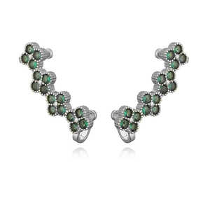 Detailed close-up of silver ear climbers with green zircon clover-shaped flower motifs