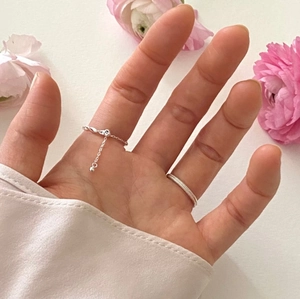 Close-up of minimalist 925 sterling silver olive bead chain ring and twisted band on a hand