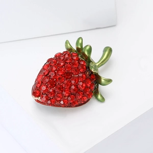 Creative fashion strawberry brooch with red rhinestones and green leaves on a white stand
