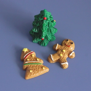 Detailed view of resin Christmas miniatures including a gingerbread man and green tree