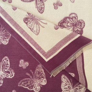 Close-up of jacquard woven butterfly pattern on burgundy cashmere scarf with fringe