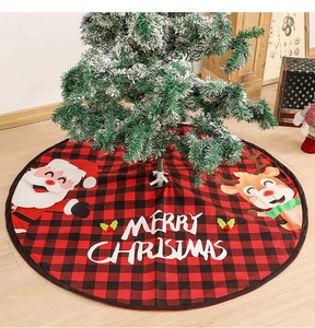 Detail of red and black plaid Christmas tree skirt with Santa Claus and reindeer graphics