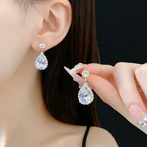 Détail de boucles d'oreilles goutte en zircone avec sertissage halo argenté brillant