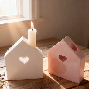 Cozy home decor featuring pink and white ceramic house candle holders with heart cutouts