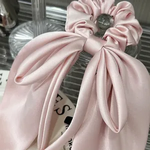 Elegant pink satin bow hair tie scrunchie with long ribbons and a pearly silk luster