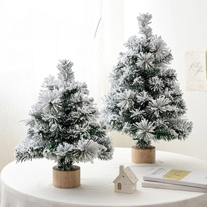 Miniature flocked cedar Christmas trees with snow effect on natural wooden bases