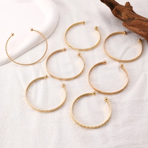 Detail of 7-piece gold alloy bangle set with twisted and engraved bohemian patterns