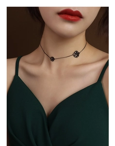 Detailed close-up of 18K gold plated steel necklace with hollow rose flower pendant on neck