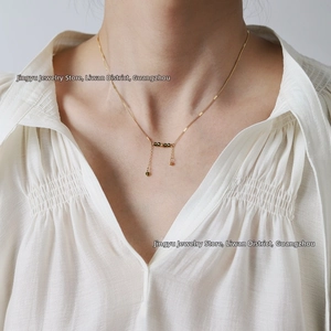 Detail of minimalist gold choker with green crystal beads and dangling tassels