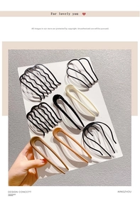 Detail of minimalist resin U-shaped hairpins and wavy hair combs in assorted neutral colors