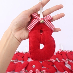 Detail of red felt letter B Christmas ornament with checkered bow and golden bell