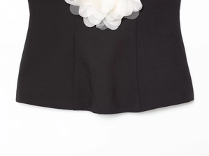 Détail de la fleur en résille 3D blanche sur le haut bustier noir élégant