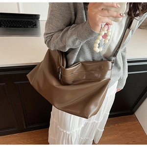 Détail du sac cabas marron foncé en similicuir avec texture souple et anneau métallique