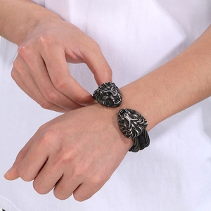 Dettaglio del bracciale da uomo in filo d'acciaio con teste di leone vintage sul polso