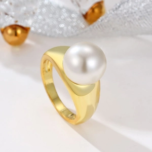 Close-up of elegant gold ring featuring a large white pearl with lustrous polished finish