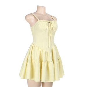 Détail d'une robe courte jaune clair avec bustier à lacets et jupe à volants