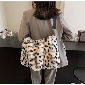 Detail of plush leopard print shoulder bag featuring soft faux fur texture and black strap