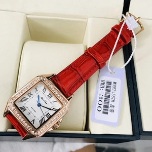 Macro detail of square rose gold watch with crystal bezel and red leather strap