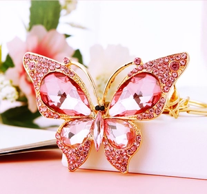 Macro shot of butterfly keychain with pink crystals and golden alloy detailing