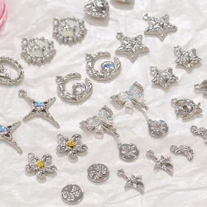 Silver alloy DIY charms with stars, moons, and butterflies on soft white fabric background