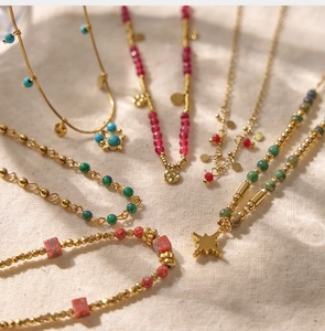 Detail view of handmade gold chain necklace with colorful crystal beads and star pendants