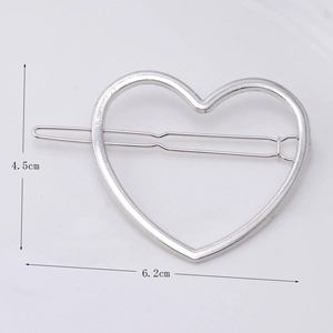 Detail view of a hollow silver metal heart hair clip with dimensions 4.5cm by 6.2cm
