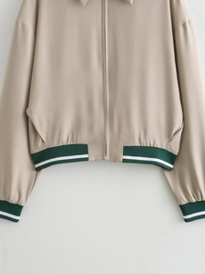 Detail of khaki jacket with green ribbed hem and cuffs featuring a smooth metal zipper