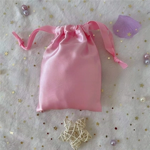 Detailed close-up of pink satin drawstring pouch for jewelry and gift packaging