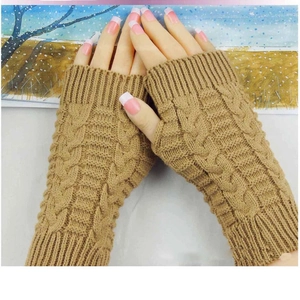 Macro shot of camel knit fingerless gloves featuring classic textured cable patterns