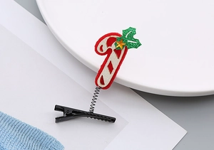 Détail d'une pince à cheveux sucre d'orge festive avec ressort et texture en feutre brillant