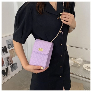 Detail of lavender quilted phone bag with gold twist lock and chain strap on model