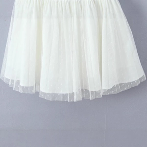 White mesh midi skirt with delicate polka dots and layered pleated texture on gray background