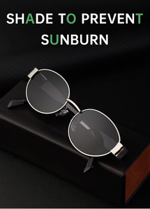 Detail of round silver metal frame sunglasses with dark lenses on black leather display