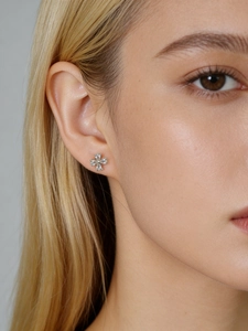 Detail view of flower-shaped S925 sterling silver studs with clear clover zircon stones