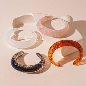 Close-up of vintage resin bangles in amber, pink, white, and black with ribbed textures