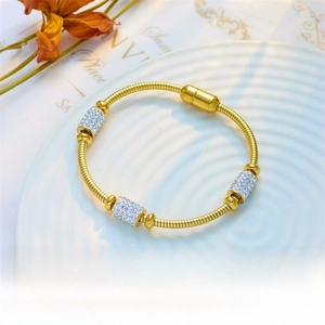 Detail of gold-plated snake bone bracelet with three pave-set rhinestone beads and magnetic clasp