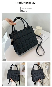Detail of black quilted square handbag with gold hooks and detachable shoulder strap