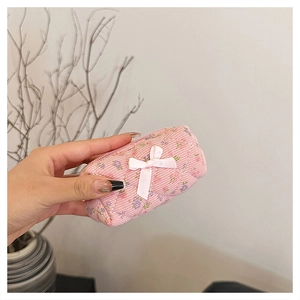 Pink floral corduroy mini makeup bag with diamond quilting and a white bow detail