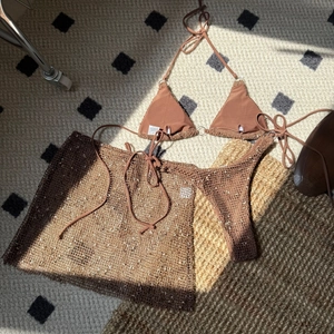 Detailed view of coffee brown three-piece bikini set with sequined mesh sarong skirt