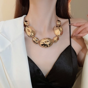 Close-up of a gold hammered beaded necklace showing detailed irregular rock textures
