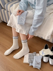 Détail de chaussettes en coton pour femmes avec bords à volants et nœuds délicats