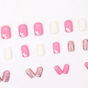 Unghie finte corte francesi rosa e bianche con motivi floreali e glitterate