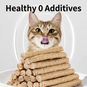 Healthy chicken breast cat treats strips stacked on a white plate with a ginger cat