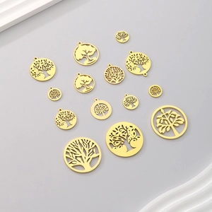 Collection de pendentifs arbre de vie évidés de différentes tailles sur fond gris