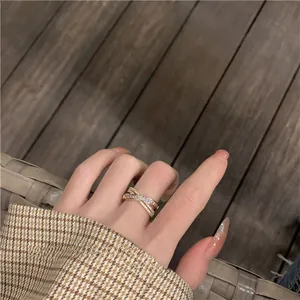 Close-up of a rose gold crisscross ring featuring intricate pave-set cubic zirconia stones