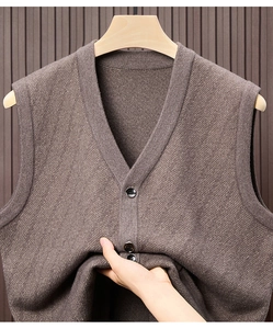 Detail der dunkelbraunen Strickweste mit V-Ausschnitt, Fischgrätenmuster und Knöpfen